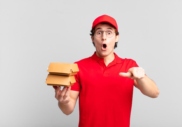 Burgers deliver boy looking astonished in disbelief, pointing at object on the side and saying wow, unbelievable