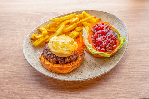 Burgers menu with veal fried goat cheese grilled brioche bread and tomato jam with caramelized onion on lettuce and fried garnish potatoes