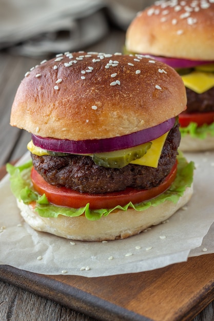 Burgers met vlees, tomaat, komkommer, kaas en ui. Amerikaanse keuken. Fast food.