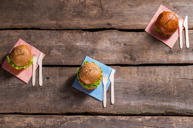 Burgers op stokjes met bestek Bestek met hamburgers op tafel Nieuw recept van gegrilde burgers Eten populair bij caféklanten