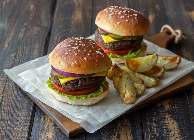 肉、トマト、きゅうり、チーズ、玉ねぎのハンバーガー。アメリカ料理。ファストフード。