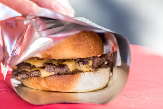 Burgers wrapped in aluminum foil cooking on the grill oil toasting preparation of homemade burgers