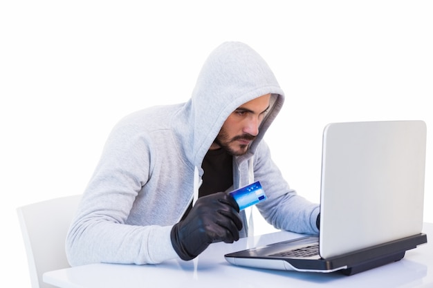 Взломщик делает онлайн-покупки с ноутбуком и кредитной картой