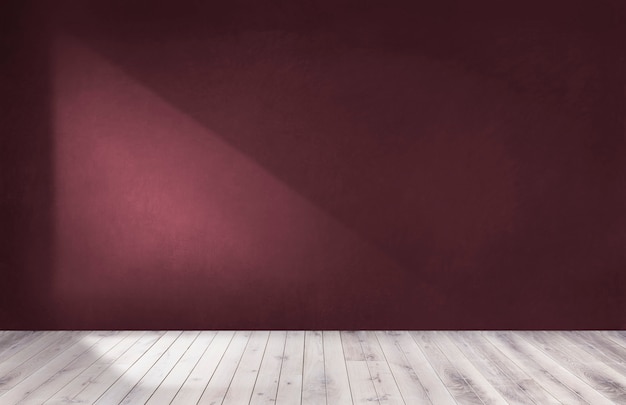 Burgundy red wall in an empty room with a wooden floor