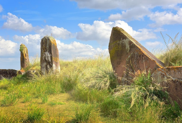 The burial mound of the 5th century BC steles of red stone under a blue sky Siberia Russia