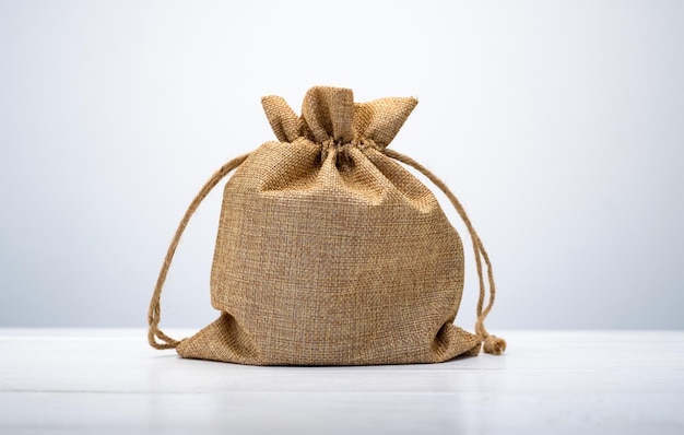 Burlap bag brown color made with eco materials on white table small rough pouch package