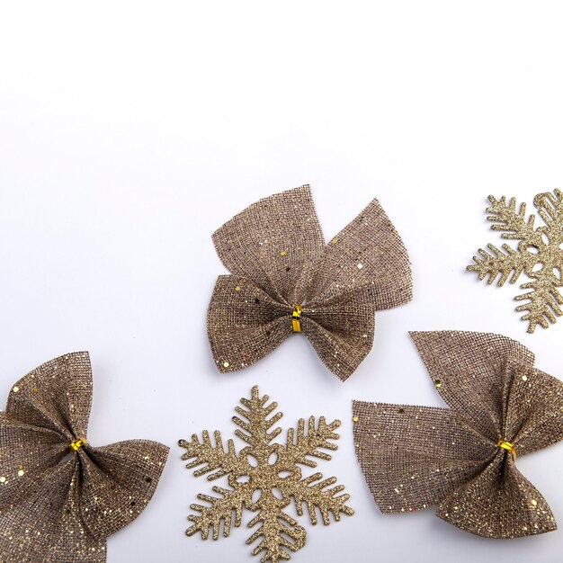 Burlap bow with gold glitter and snowflakes on white background Christmas holiday decor