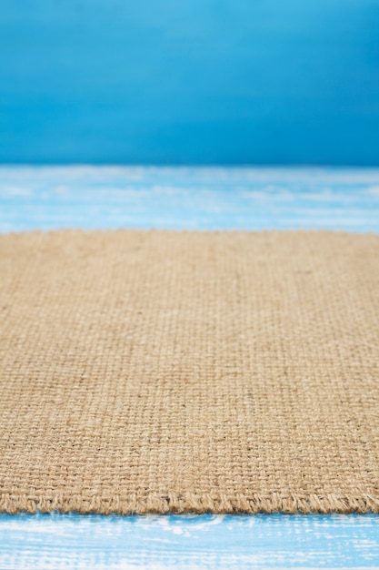 Burlap hessian sacking cloth on wooden background table in front view