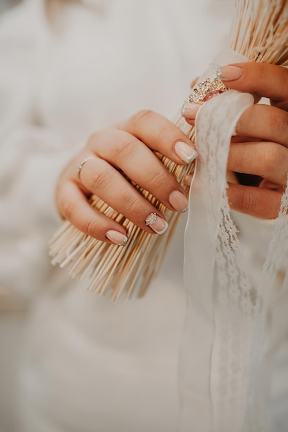 Photo burly large female fingers festive manicure with stones and sequins holding brides dried flowers