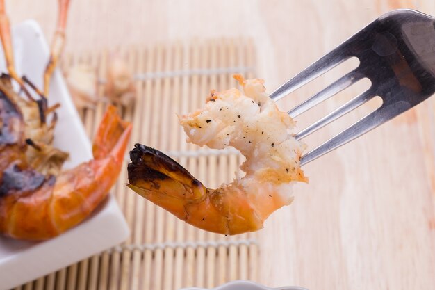 Burn shrim and Seafood sauce on wooden table.