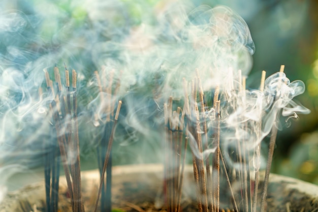 Foto bastoncini di incenso aromatico che brucia. incenso per pregare indù e buddha