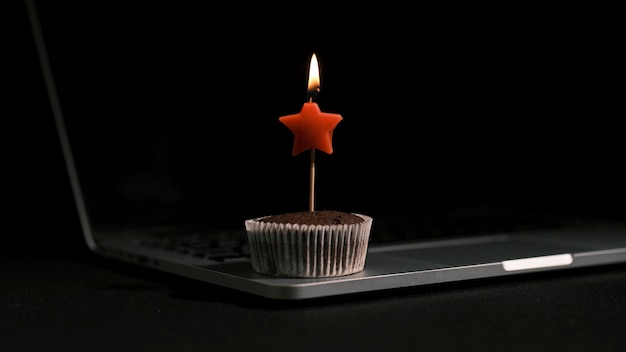 A burning birthday candle on a chocolate cake