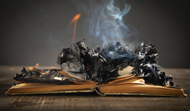 Libro in fiamme sul tavolo di legno