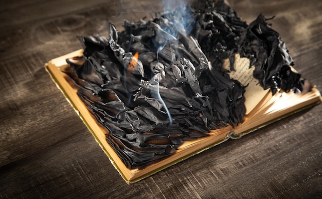 Libro in fiamme sul tavolo di legno