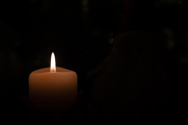 Burning candle on black background