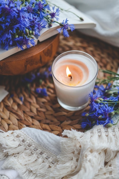 Burning candle book and cornflowers aesthetic summer photo