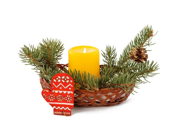 Burning candle cone and natural fir tree branches in wicker basket