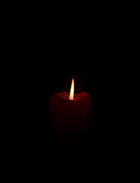 Photo burning candle in the dark