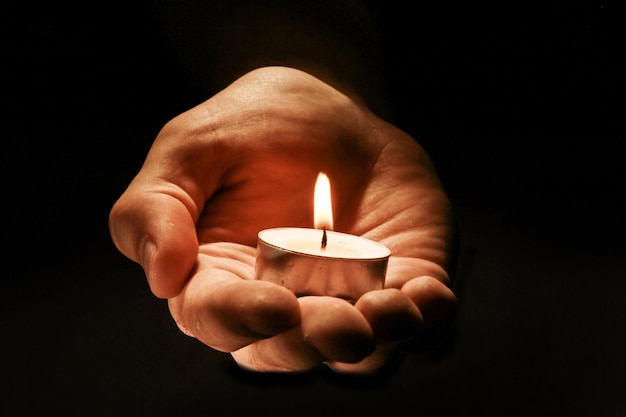 Burning candle in male hand,  religion concept