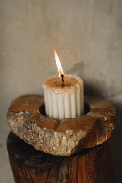 A burning candle in a stone stand Natural details in the interior
