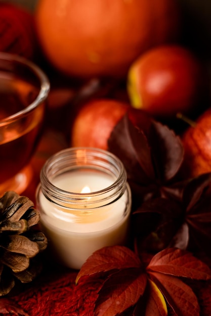 Burning candle next to tea and autumn fruits Autumn Composition