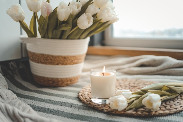 Burning candle and tulips in home interior