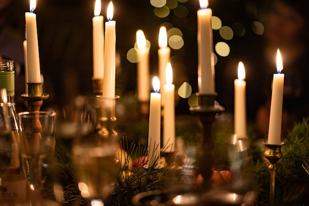 Burning candles in candlesticks in a dark interior