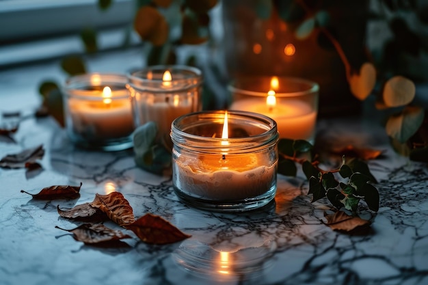 Горящие свечи в подсвечниках на мраморном столе и зеленых листьях