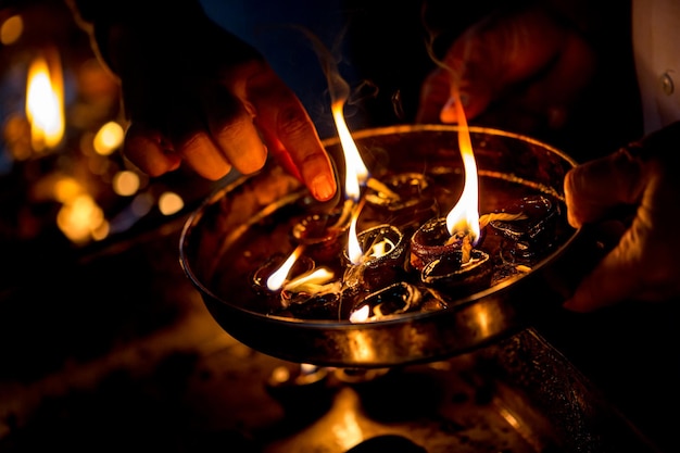 Burning candles in the Indian temple. Diwali the festival of lights. Warning - authentic shooting with high iso in challenging lighting conditions. A little bit grain and blurred motion effects.