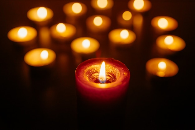 Burning candles. Shallow depth of field. Many candles burning at night. Many candle flames glowing.