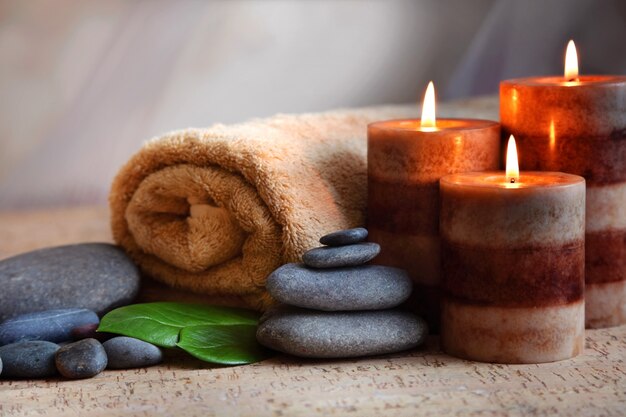 Burning candles and a towel. Stone therapy. Spa treatments.