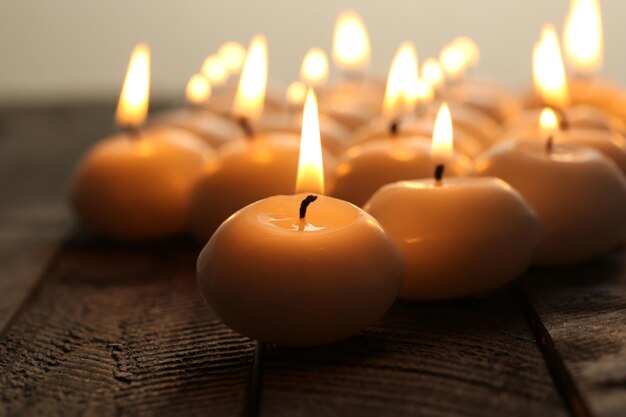 Burning candles on wooden table close-up