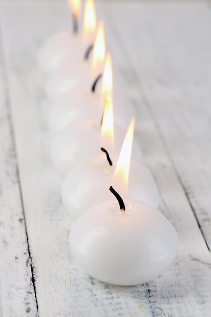 Burning candles on wooden table close-up