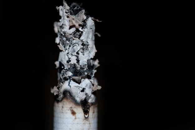 Burning cigarette on black background