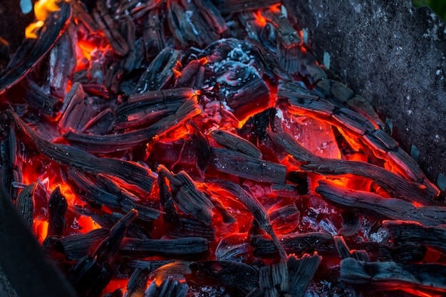 Burning coals. decaying charcoal. texture embers closeup. burning charcoal in the background.