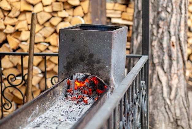 Carboni ardenti in una griglia metallica per friggere carne e verdure. cucinare su un fuoco da campo.