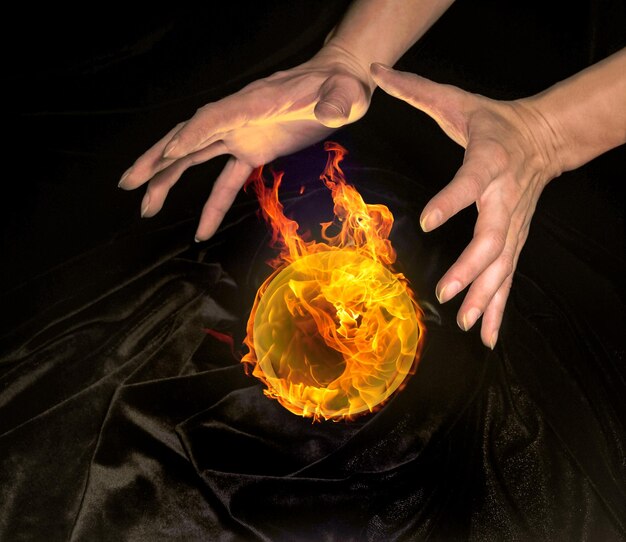 burning crystal ball and hands