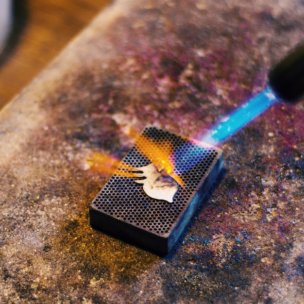 Burning details of jewelry on a stone with a gas burner. Home workshop, handmade. 