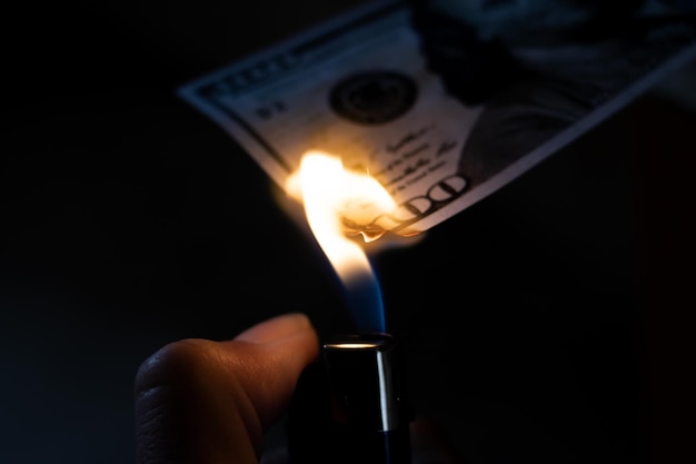 Фото Горящий доллар и зажигатель в руке крупный план