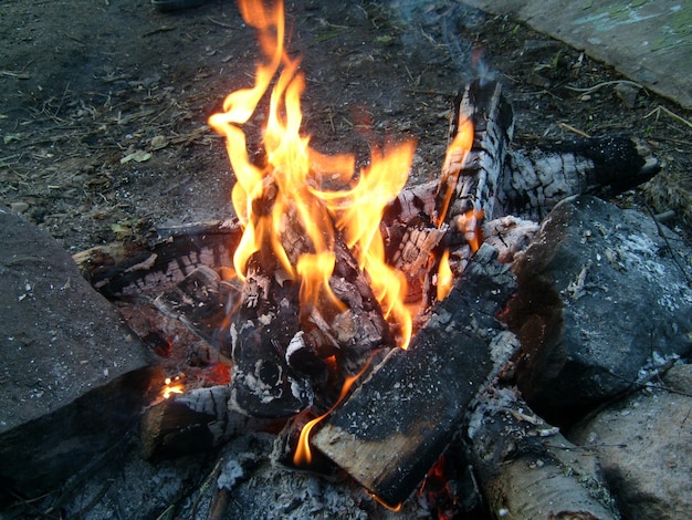 Burning firewood in a fire bright fire tongues of flame of
orange color big stones boulders around a campfire