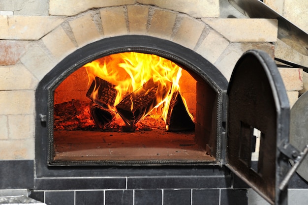 Photo burning firewood in a pizza oven