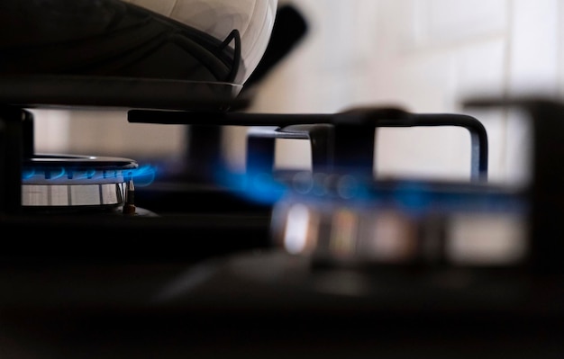 Burning gas burner with blue flames on kitchen black gas stove with a bokeh effect gasoline Banner