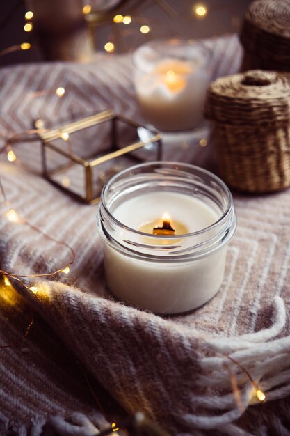 Burning handmade candle with wooden wick in glass jar