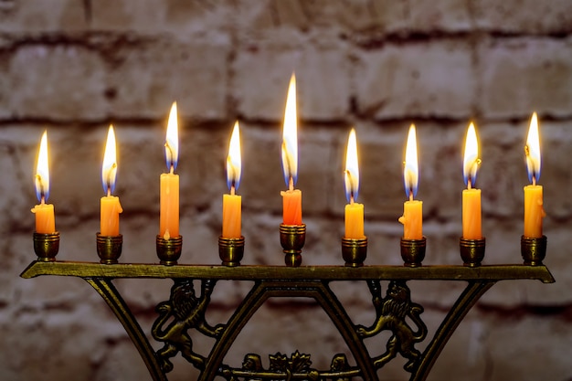 Burning hanukkah candles in a menorah on colorful candles from a menorah