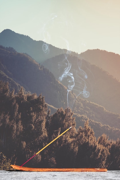 Горящая ароматическая палочка в азиатских горах Вертикальная композиция с копировальным пространством
