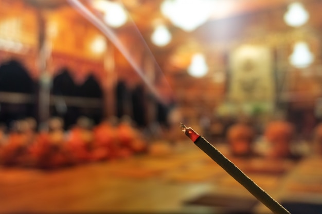 Burning incense sticks with smoke, joss sticks burning at a vintage buddhist temple