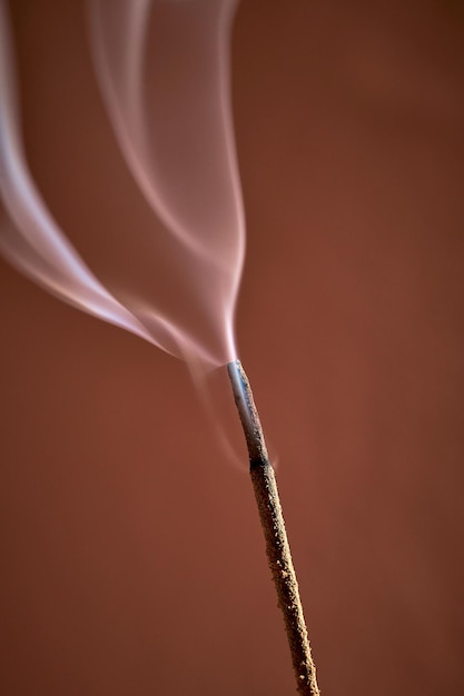 A burning incense for yoga or meditation Minimalistic concept with warm colors