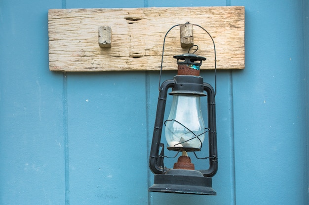 Burning kerosene lamp hang on the wooden wall