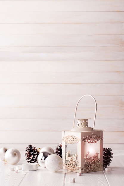 Burning lantern in the snow with christmas decoration