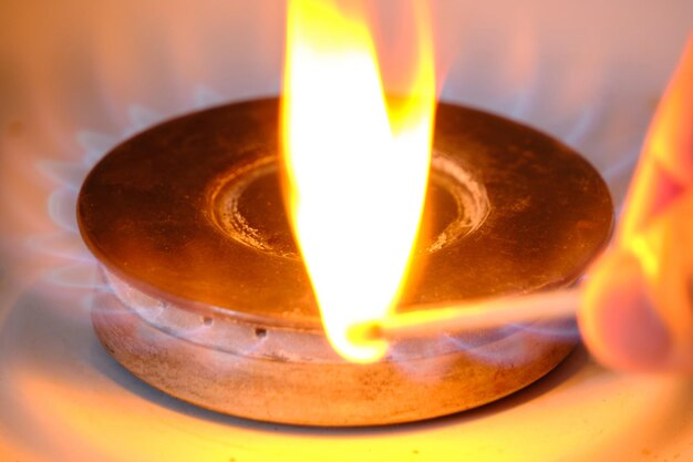 Burning match against background blue flame burning burner